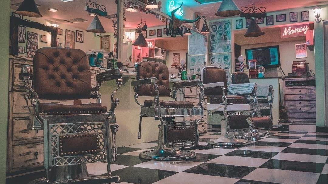 Sillas clásicas de barbero en cuero sobre piso de ajedrez